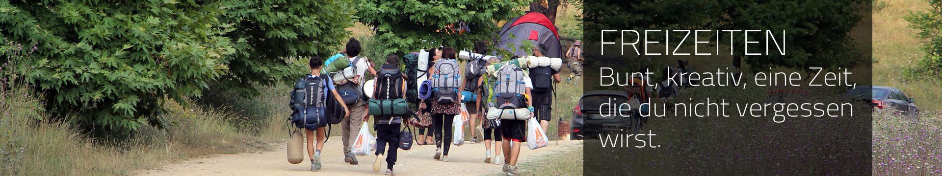 Jugendliche mit Rucksack gehen zu einem Waldcampingplatz
